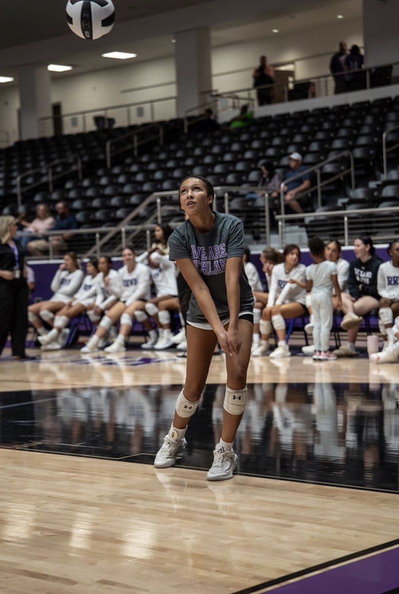Arielle Akinwumi in a low ready stance, watching play on the court